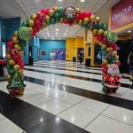 Arco de globos navideño para evento de Cineplanet, decoración festiva para celebraciones temáticas.