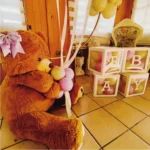 Montaje de baby shower con tonos pastel y osito